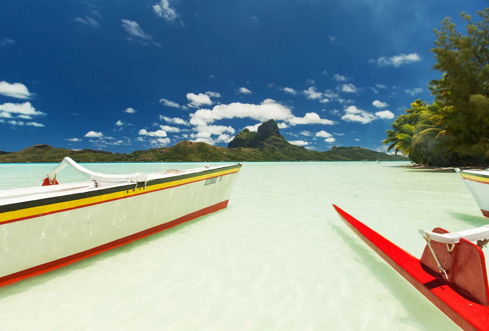 Bateaux traditionnels Keishi Tours sur le lagon turquoise de Bora Bora avec le mont Otemanu en arrière-plan